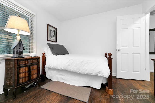 bedroom with dark hardwood / wood-style flooring