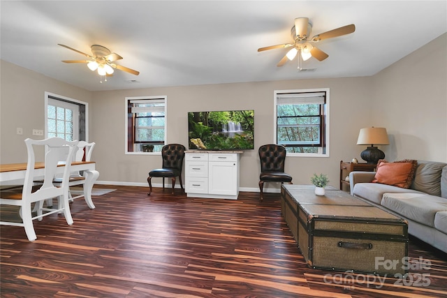 living room featuring a healthy amount of sunlight, ceiling fan, and dark hardwood / wood-style flooring