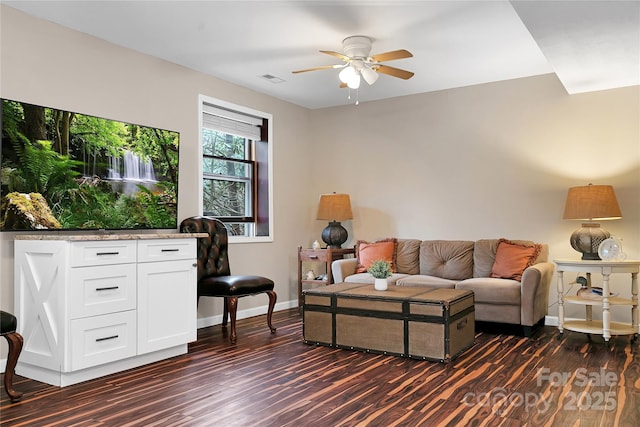 living room featuring dark wood-type flooring and ceiling fan