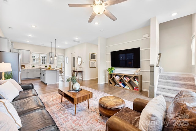 living room featuring light hardwood / wood-style floors and ceiling fan