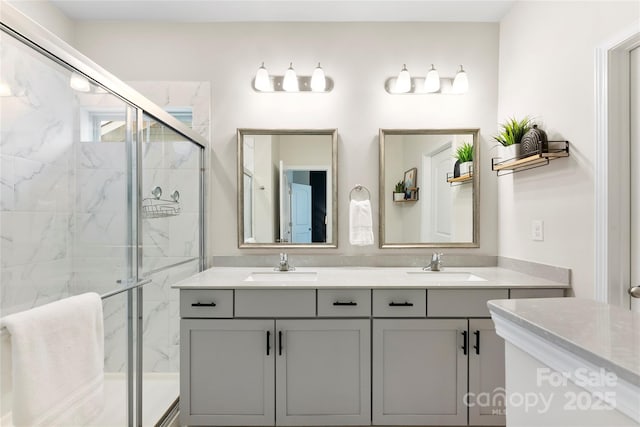 bathroom featuring a shower with shower door and vanity