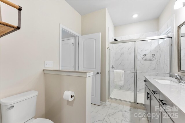 bathroom with a shower with shower door, toilet, and vanity