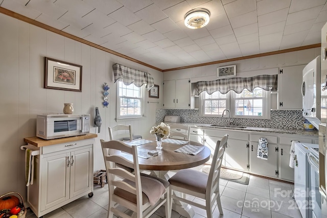 kitchen featuring white cabinetry, sink, white appliances, and light tile patterned floors