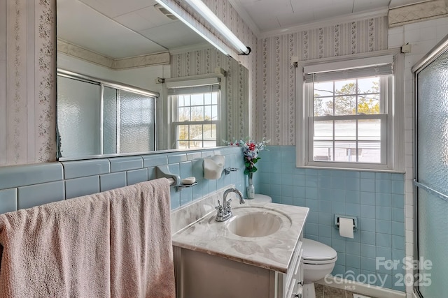 bathroom featuring walk in shower, toilet, crown molding, tile walls, and vanity