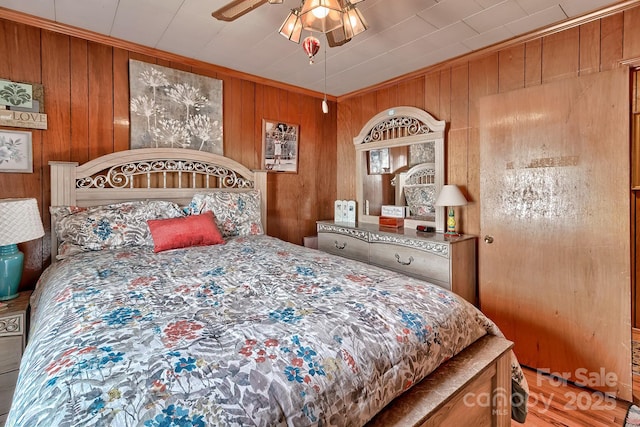 bedroom with wooden walls and ceiling fan