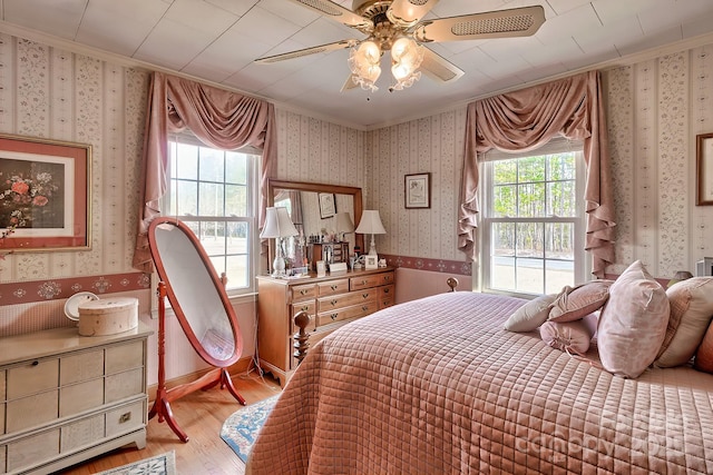 bedroom featuring ornamental molding, light hardwood / wood-style floors, and ceiling fan