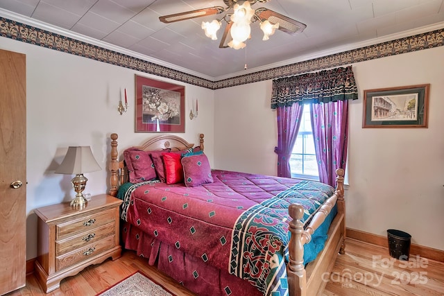 bedroom featuring hardwood / wood-style floors, crown molding, and ceiling fan