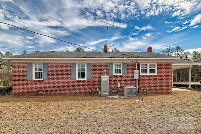 rear view of property with cooling unit, a lawn, and a carport