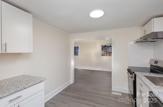 kitchen with light stone counters, stainless steel electric stove, white cabinets, decorative backsplash, and crown molding