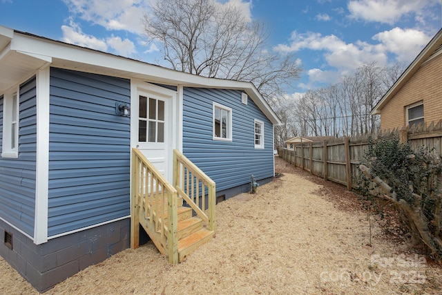 view of side of property featuring crawl space and fence