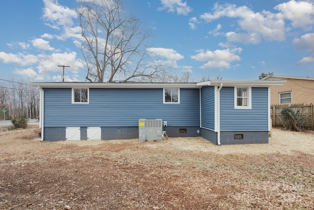 back of house featuring central AC unit, crawl space, and fence