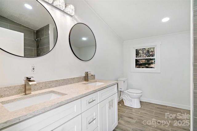 bathroom featuring toilet, vanity, and crown molding