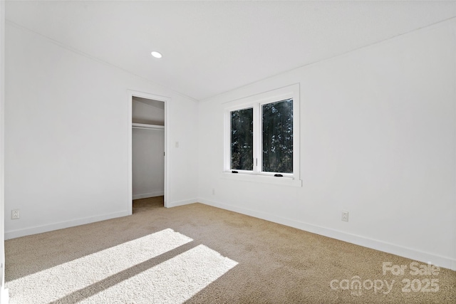 unfurnished bedroom with lofted ceiling, light colored carpet, and a closet