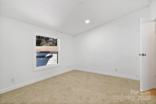 unfurnished room with a textured ceiling and light colored carpet