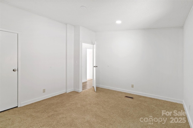 carpeted spare room featuring ornamental molding