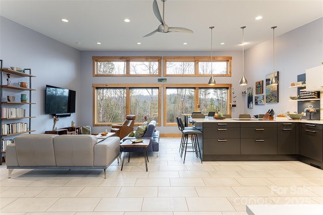 living room featuring ceiling fan and a high ceiling