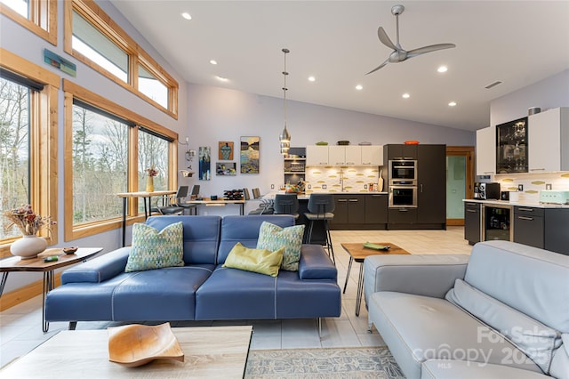 living room with bar, high vaulted ceiling, light tile patterned floors, ceiling fan, and beverage cooler