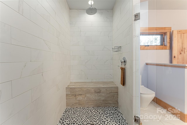 bathroom with tiled shower and toilet