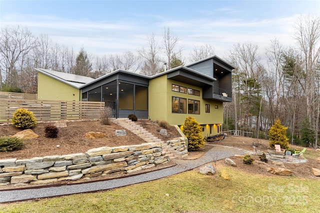 view of front of house featuring an outdoor fire pit and a sunroom