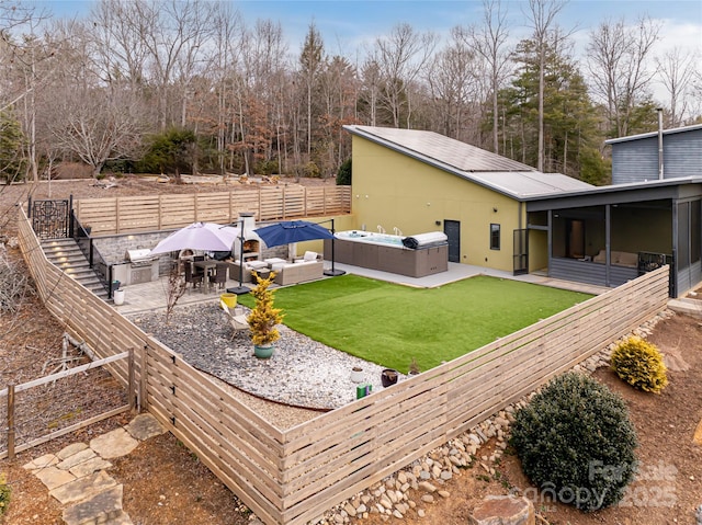 view of yard featuring a sunroom, a hot tub, an outdoor hangout area, and a patio area