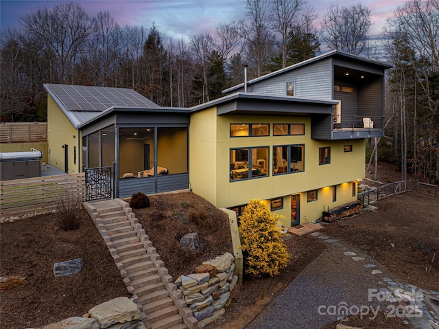 contemporary house featuring a sunroom and solar panels