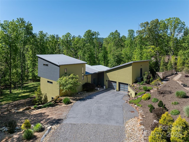 15 Sourwood Ln, Fletcher, NC 28732 - mid-century inspired home with driveway, an attached garage, metal roof, fence, and a forest view