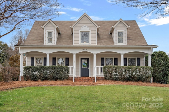 new england style home featuring a porch and a front yard