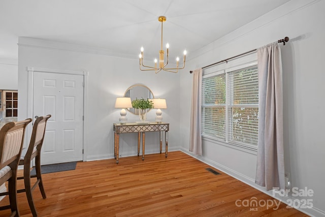 dining room with ornamental molding, a chandelier, and hardwood / wood-style flooring