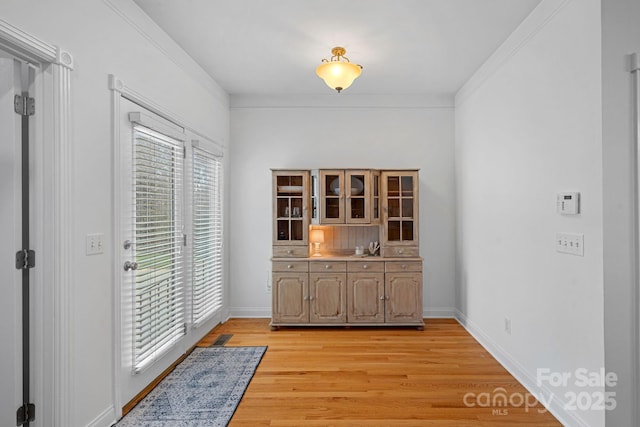 interior space with light hardwood / wood-style flooring and crown molding