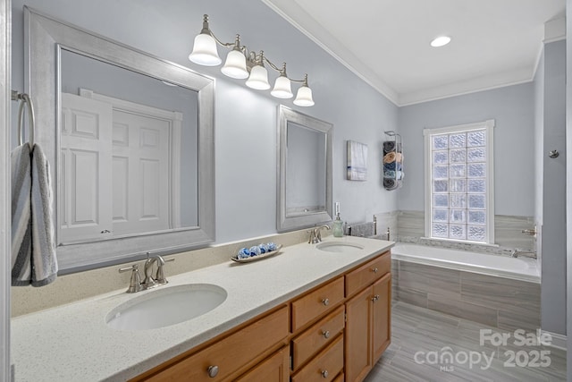 bathroom with tiled bath, ornamental molding, and vanity