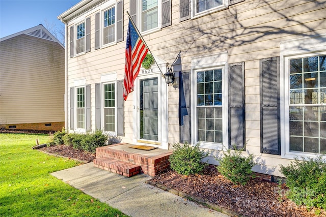 view of exterior entry featuring a yard