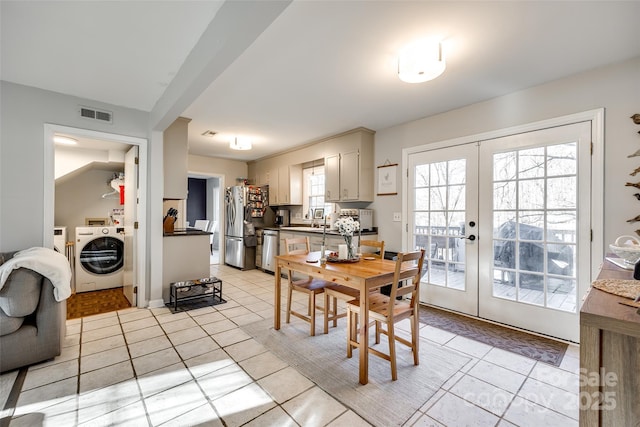 dining space with sink, french doors, washer / dryer, and light tile patterned flooring