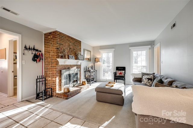 living room with light tile patterned floors and a brick fireplace