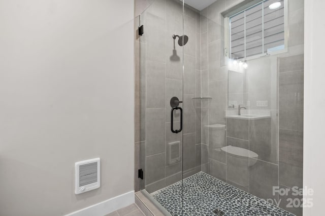 bathroom featuring heating unit, tile patterned floors, and a shower with door