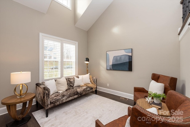 living room with hardwood / wood-style flooring and a towering ceiling