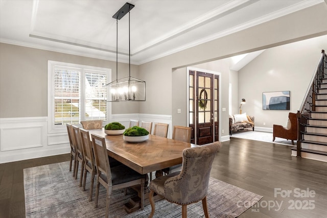 dining room with crown molding, dark hardwood / wood-style floors, an inviting chandelier, and a tray ceiling