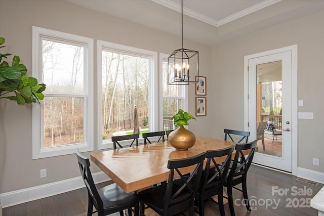 dining area with crown molding, plenty of natural light, dark hardwood / wood-style floors, and a notable chandelier