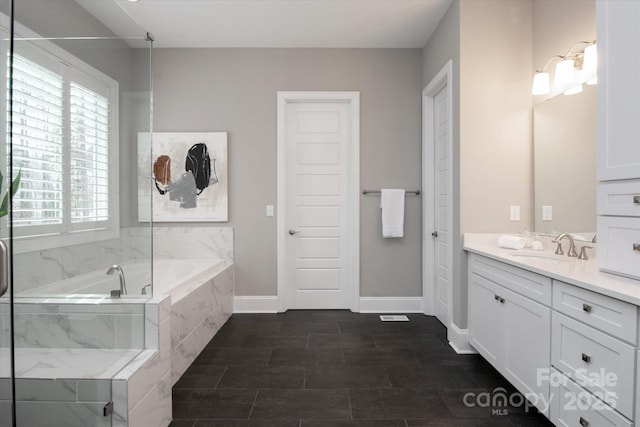 bathroom featuring vanity and tiled tub