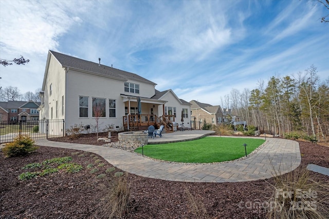 rear view of property with a yard and a patio area