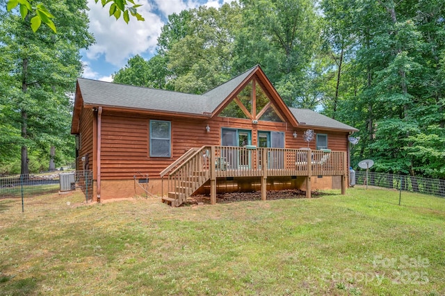 rear view of property featuring a deck, central air condition unit, and a lawn