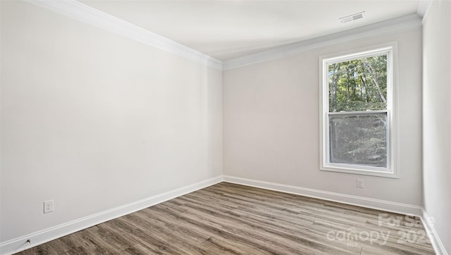 empty room featuring ornamental molding and hardwood / wood-style flooring