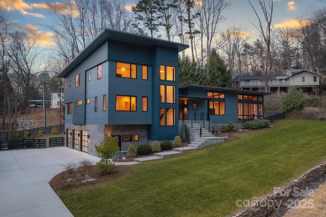 contemporary home featuring a garage and a lawn