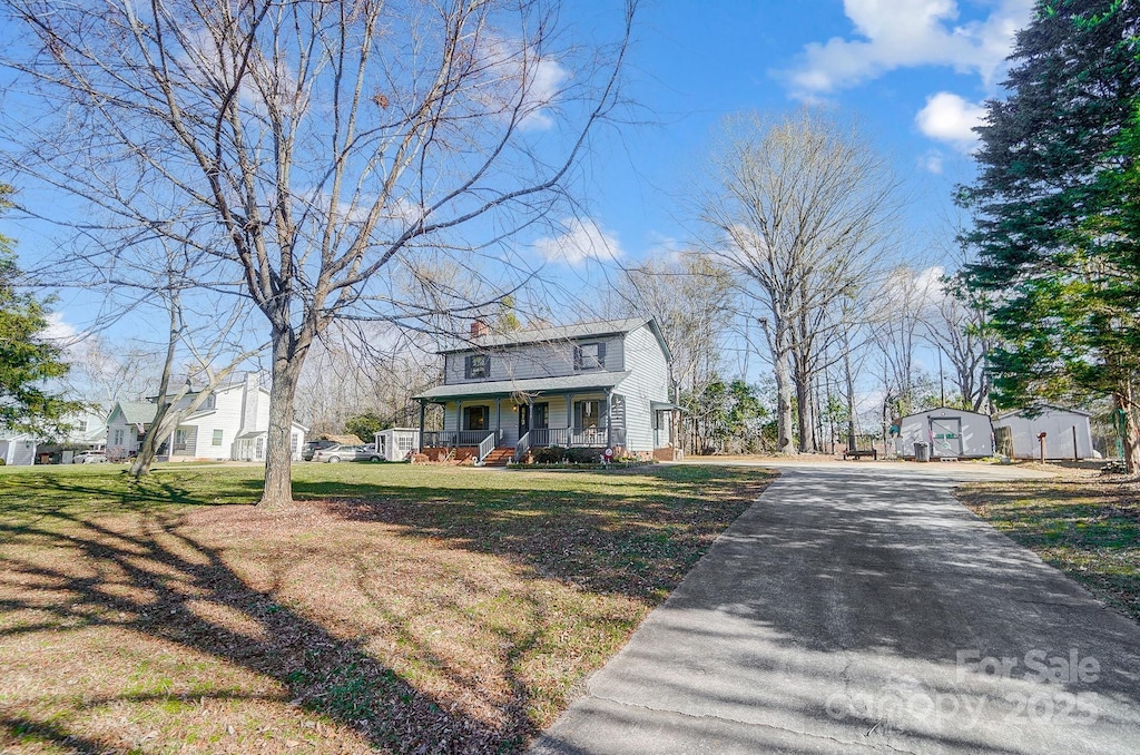 view of front of house with covered porch and a front lawn