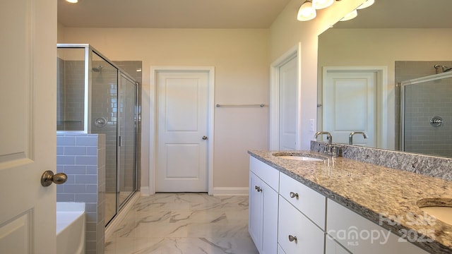 bathroom featuring a shower with door and vanity