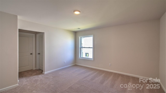 unfurnished room with light colored carpet