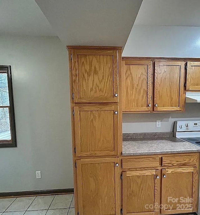 kitchen with brown cabinetry, extractor fan, electric stove, and light tile patterned floors