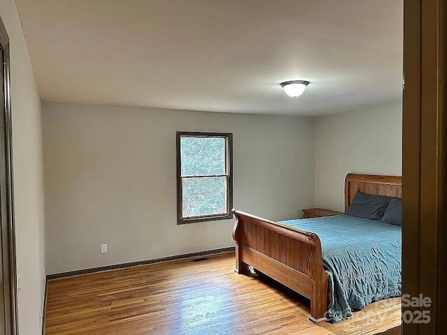 bedroom featuring baseboards and wood finished floors