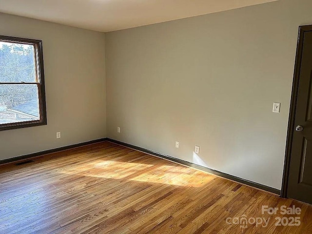 unfurnished room featuring baseboards and wood finished floors