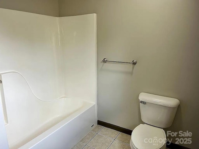 bathroom featuring baseboards, tile patterned flooring, and toilet