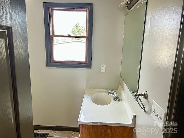 half bathroom with visible vents, tile patterned floors, and vanity